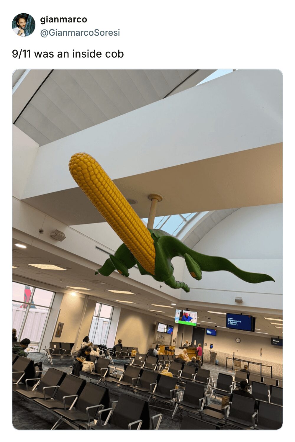 A giant corn on the cob sculpture hanging from an airport ceiling with a punny caption.
