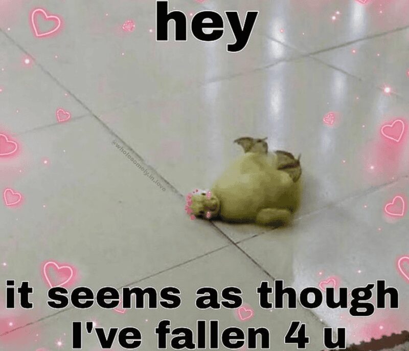 cute relationship meme showing a small, round green toy creature lying flat on its back on a tile floor. The image is filtered with pink sparkles and hearts, captioned: "hey it seems as though I've fallen 4 u."