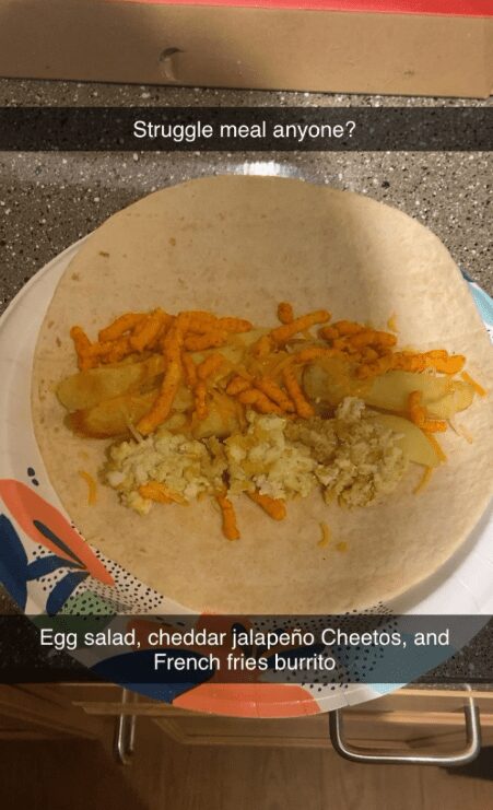 Flour tortilla filled with egg salad, jalapeño Cheetos, and French fries labeled as a struggle burrito.