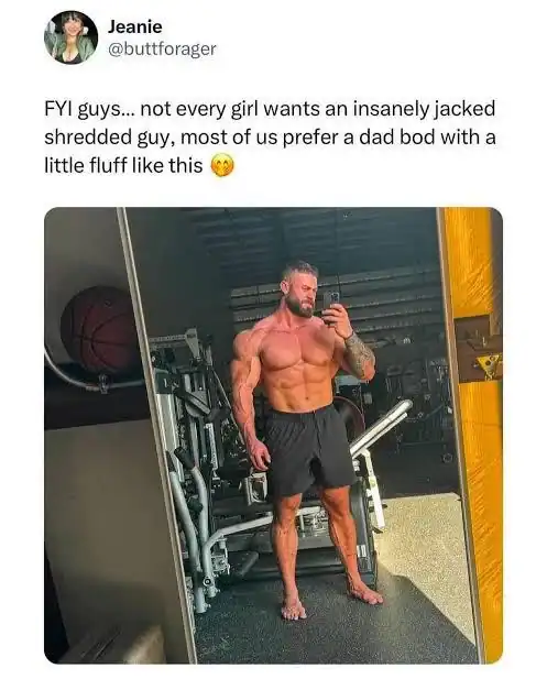 A deeply sarcastic workout meme showing an incredibly shredded and massive bodybuilder posing in the mirror, hilariously captioned by a user claiming women just want a "dad bod with a little fluff" in this classic gym meme.