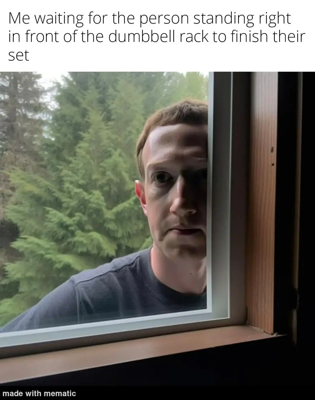 deeply relatable gym meme showing Mark Zuckerberg staring blankly and creepily through a window, perfectly capturing the intense impatience of waiting for someone to finally step away from the dumbbell rack in this funny workout meme.