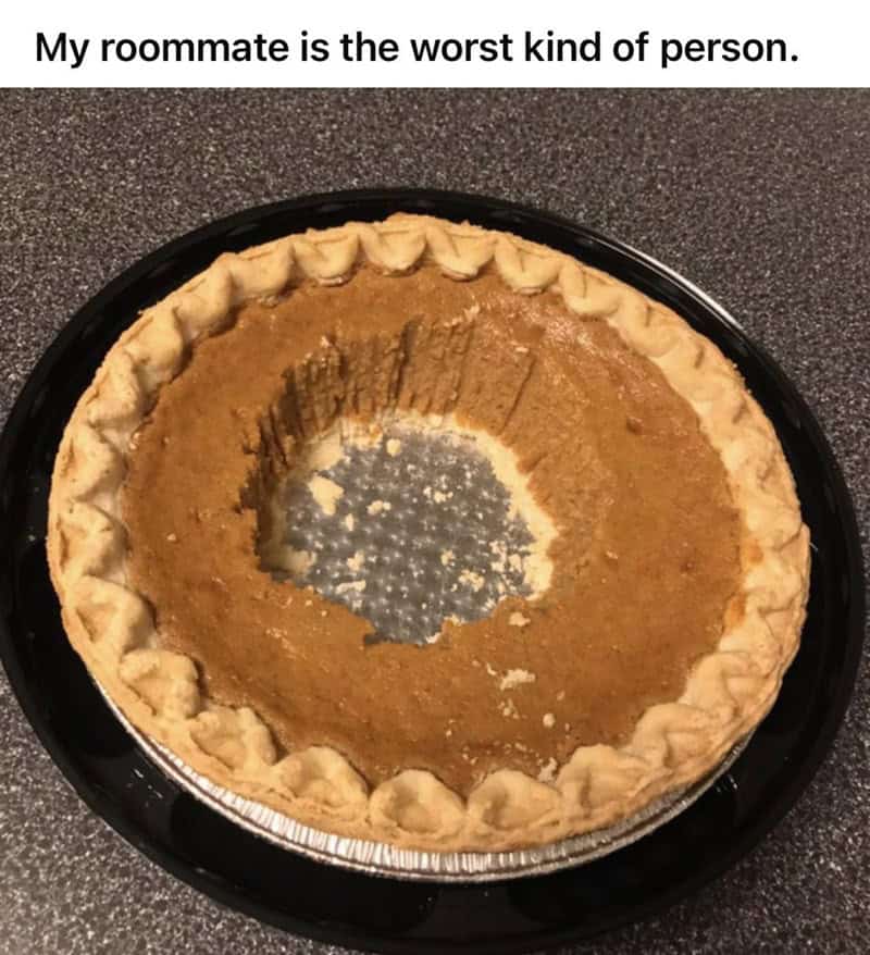 Evidence that one of the worst roommates is "the worst kind of person." A large pumpkin pie sits on a counter, but instead of cutting a normal slice, someone has scooped out a giant circle from the exact center, leaving only a ring of crust and filling.