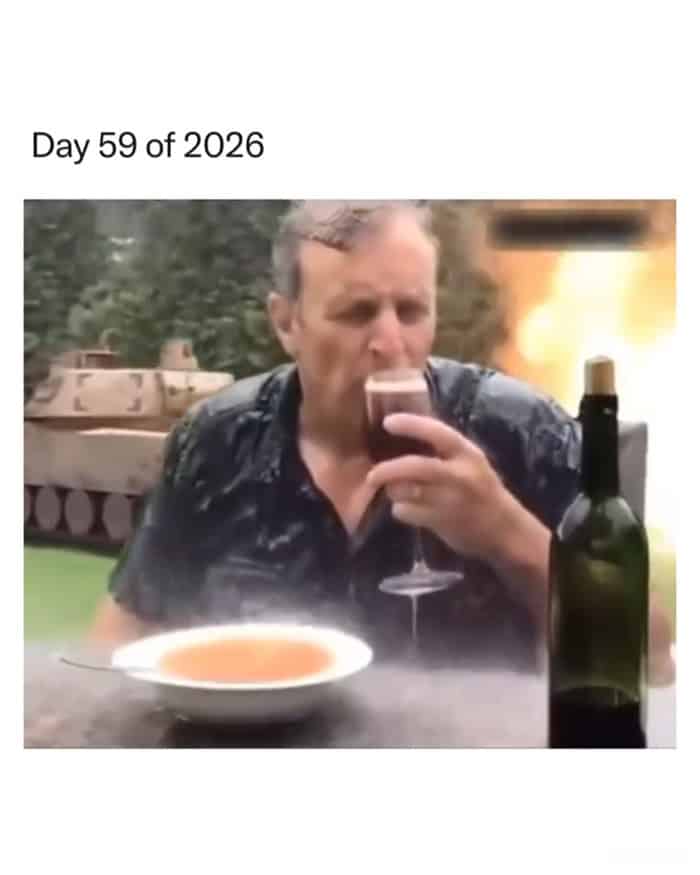 A man calmly sipping wine at a table while a tank drives through his backyard.