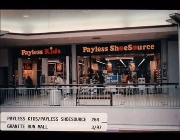 A nostalgic 90s mall glamour shots view of a dual Payless ShoeSource and Payless Kids storefront. This 1997 shot from Granite Run Mall captures the simple black-and-orange signage and the inevitable "Buy One Get One" posters in the windows.