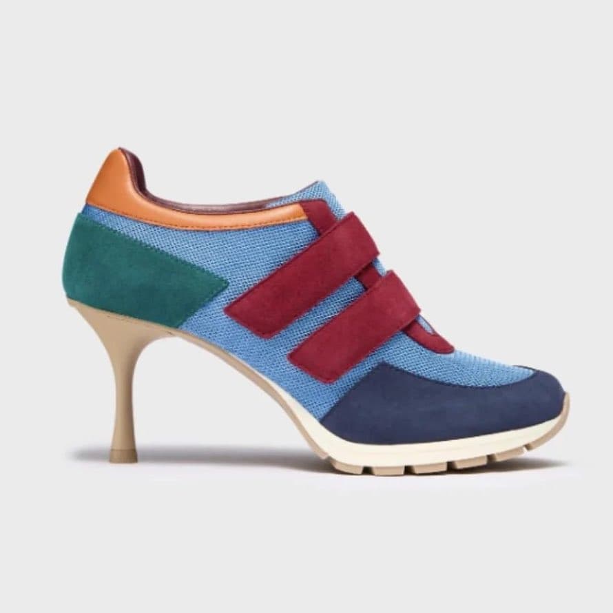 A footwear hybrid featuring the colorful, multi-paneled upper of a children's Velcro sneaker mounted onto a thin, elegant stiletto heel.