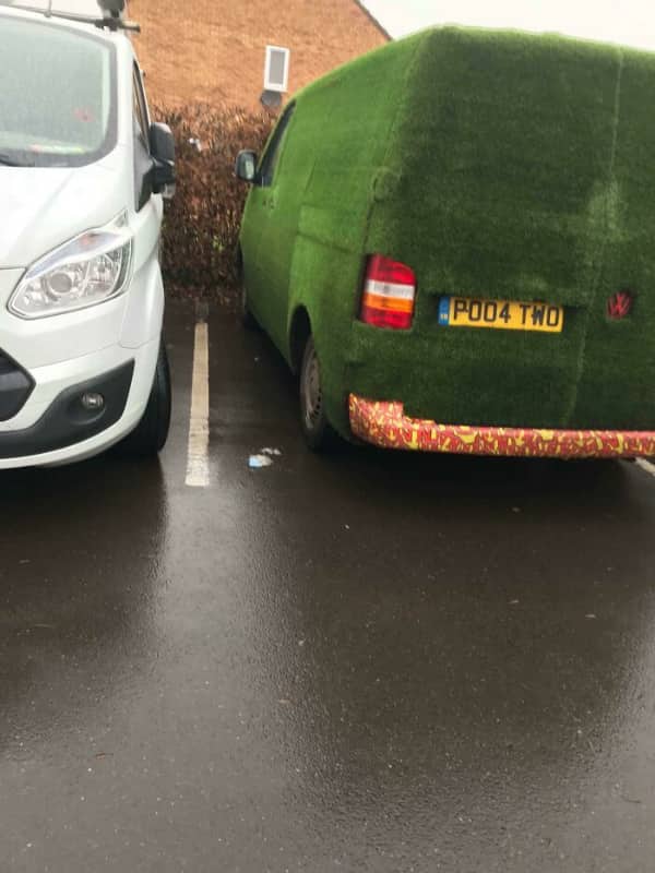 Volkswagen van completely covered in artificial green turf grass as exterior wrap