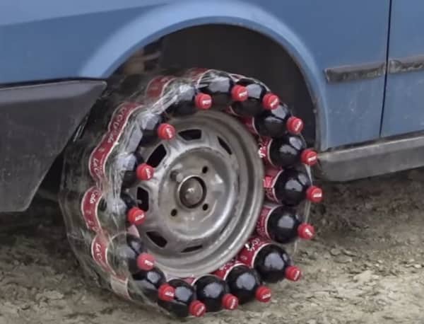 Car rim wrapped in Coca-Cola bottles secured with plastic wrap as makeshift tire replacement