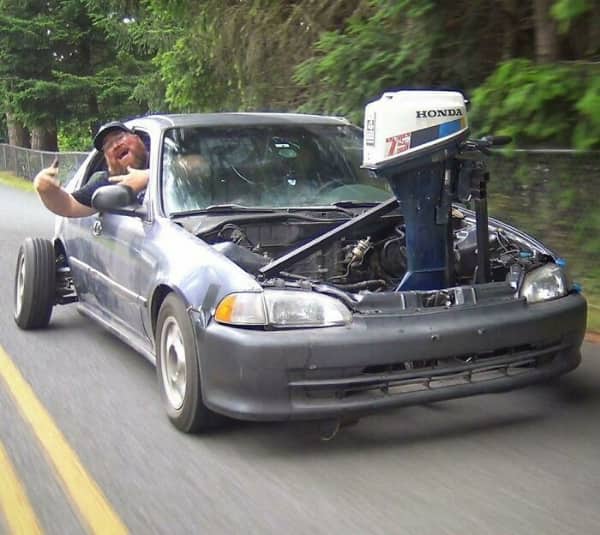 Honda Civic driving with outboard boat motor mounted under open hood as engine swap
