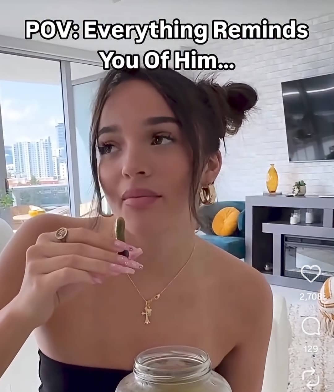 Young woman holding a tiny pickle with a caption about being reminded of an ex-boyfriend.