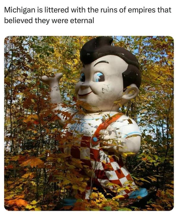 dry humor midwest meme featuring a large, weathered "Big Boy" restaurant statue partially hidden by autumn leaves in a forest. The caption reads: "Michigan is littered with the ruins of empires that believed they were eternal."