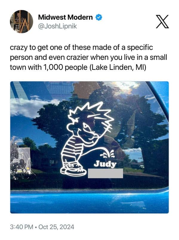 A hyper-local midwest meme from @JoshLipnik featuring a custom car window decal. It shows the "peeing Calvin" character urinating on the name "Judy." The caption points out how crazy it is to target a specific person in a small town of only 1,000 people like Lake Linden, MI.