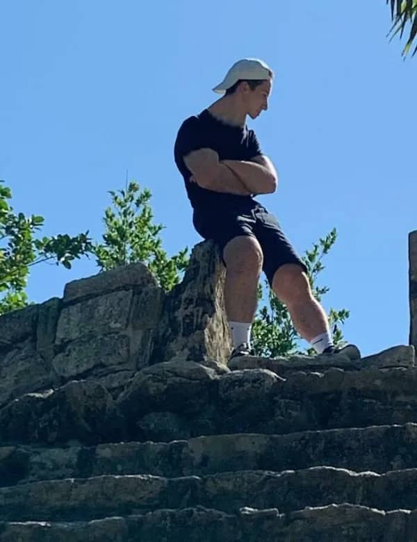 Man standing on ancient ruins with suspiciously elongated legs from bad body editing