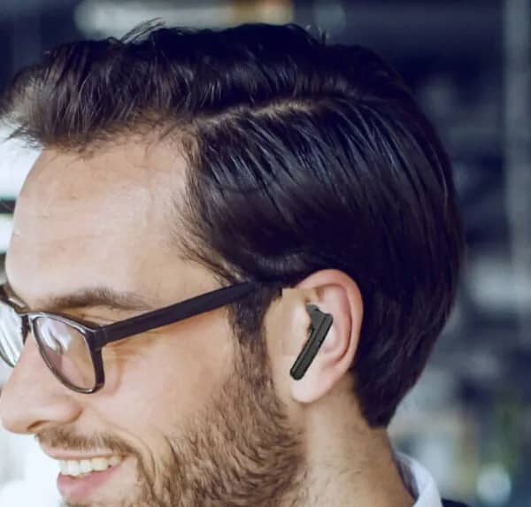 Man wearing glasses with wireless earbud inserted at a completely wrong backwards angle