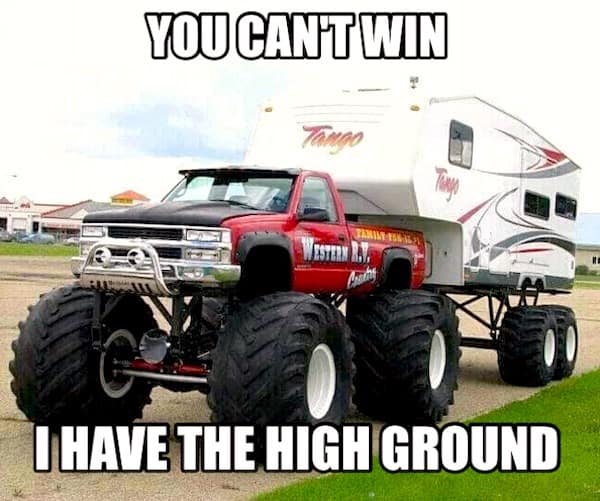 A towering redneck DIY car setup featuring a red Chevrolet pickup truck converted into a monster truck with massive tractor tires. It is towing a large "Tango" camper that has been lifted on a custom high-clearance frame to match. The meme text reads: "YOU CAN'T WIN. I HAVE THE HIGH GROUND."