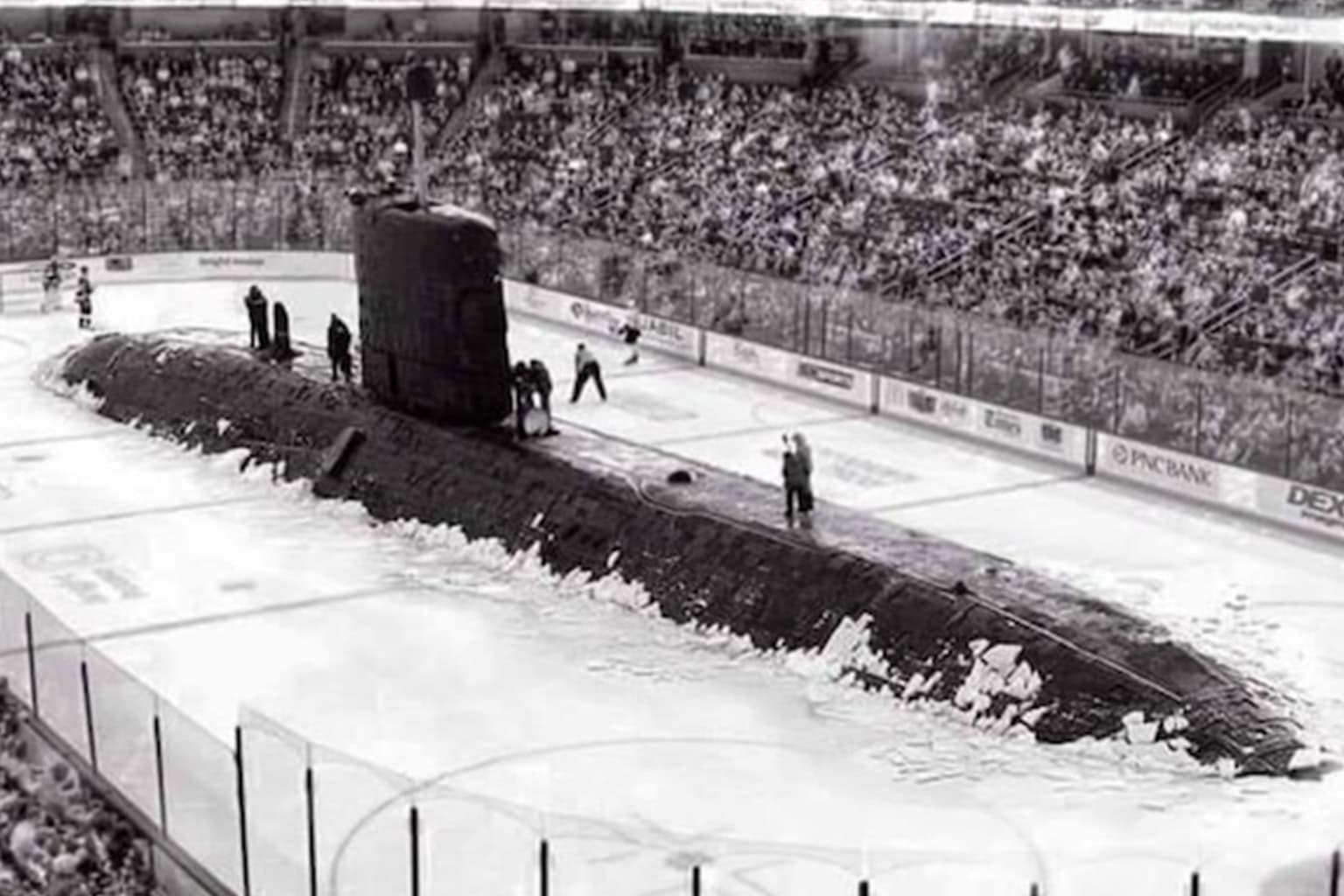 A dump of submarine memes featuring two sailors dressed as crash-test dummies operating a sub's controls, a polar bear gnawing on the exposed rudder of a surfaced submarine, and a massive black submarine having crashed through the center of an ice hockey rink.