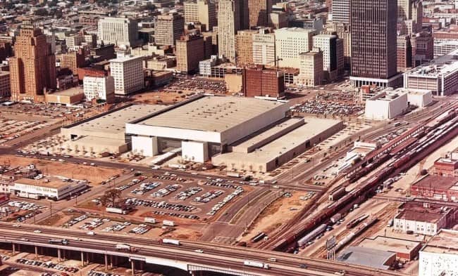 Aerial view of downtown convention center surrounded by surface parking lots and urban highway sprawl