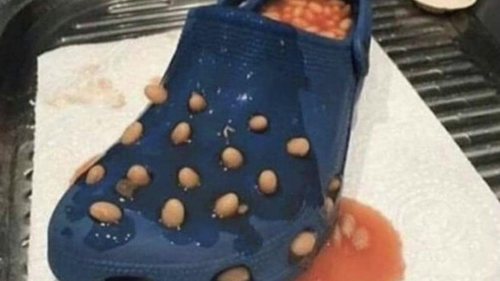 Blue Croc shoe stuffed with baked beans leaking through its holes, one of the classic memes that never gets old.