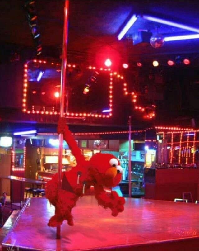 Elmo plush clinging to a pole on a neon lit bar stage in an Elmo meme