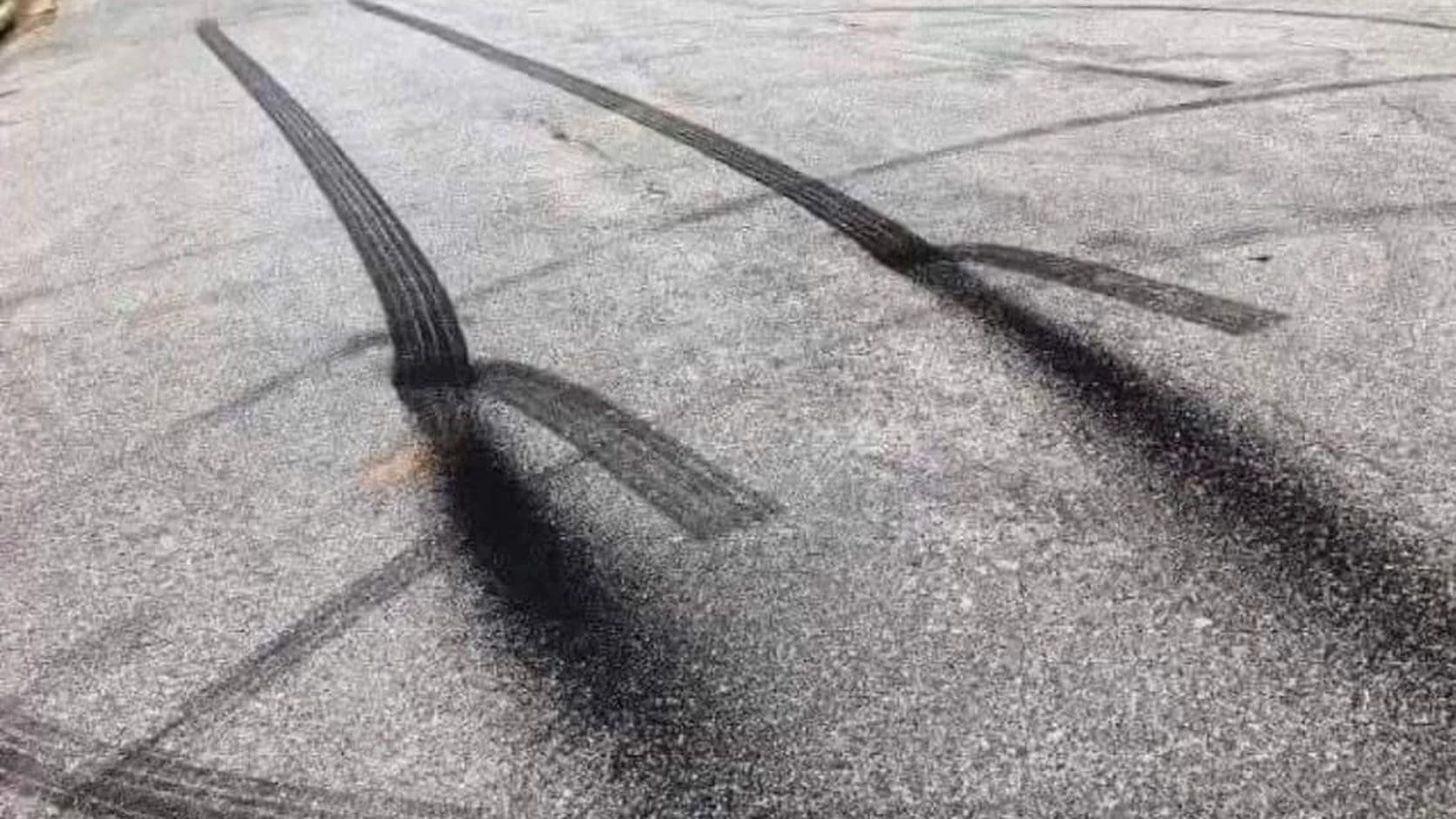 Black tire burnout marks on asphalt whose shadows make them look 3D, from this Monday meme dump.