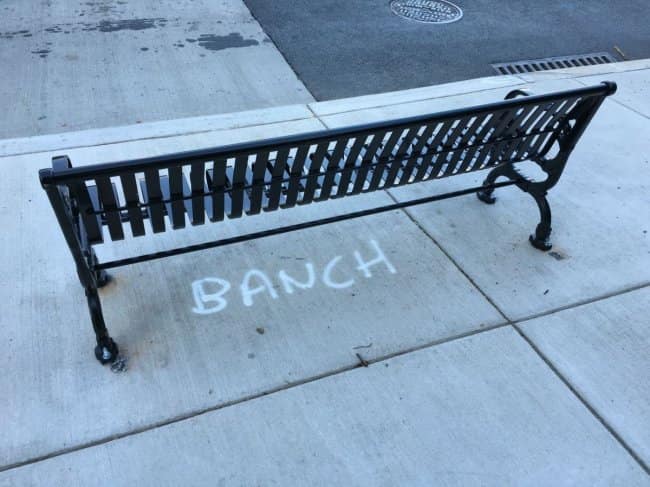 Sidewalk bench with the word BANCH written in chalk beneath it, classic spelling fails.